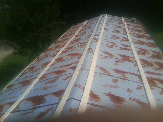 Rusted metal roof panels with new wood purlins before replacement — Storm Damage Roof Repair in Southold by Roofing Brothers