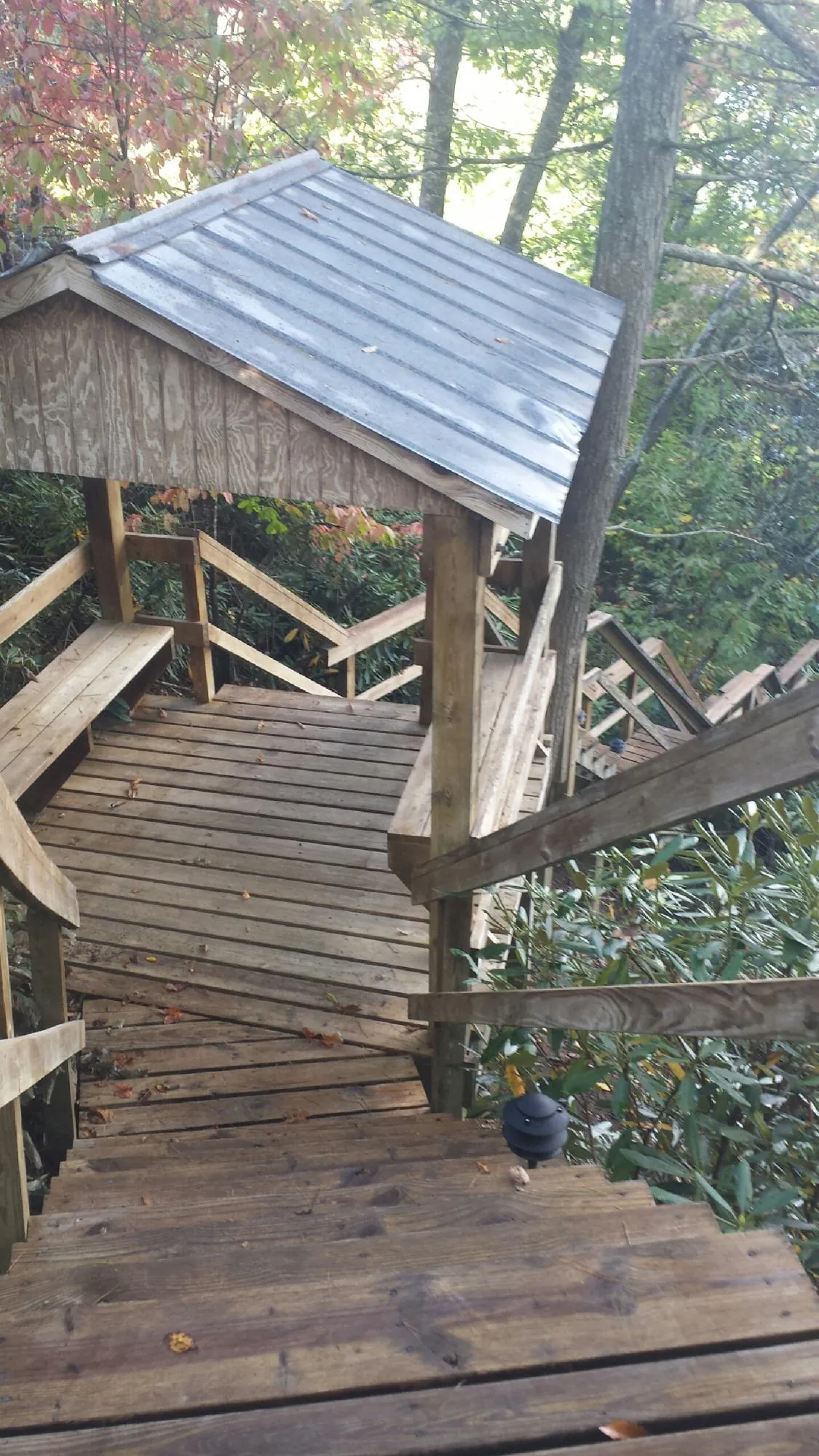 Metal roofed shelter over wooden steps on a wooded walkway — Skylight Repair & Installation work by our crew in Southold