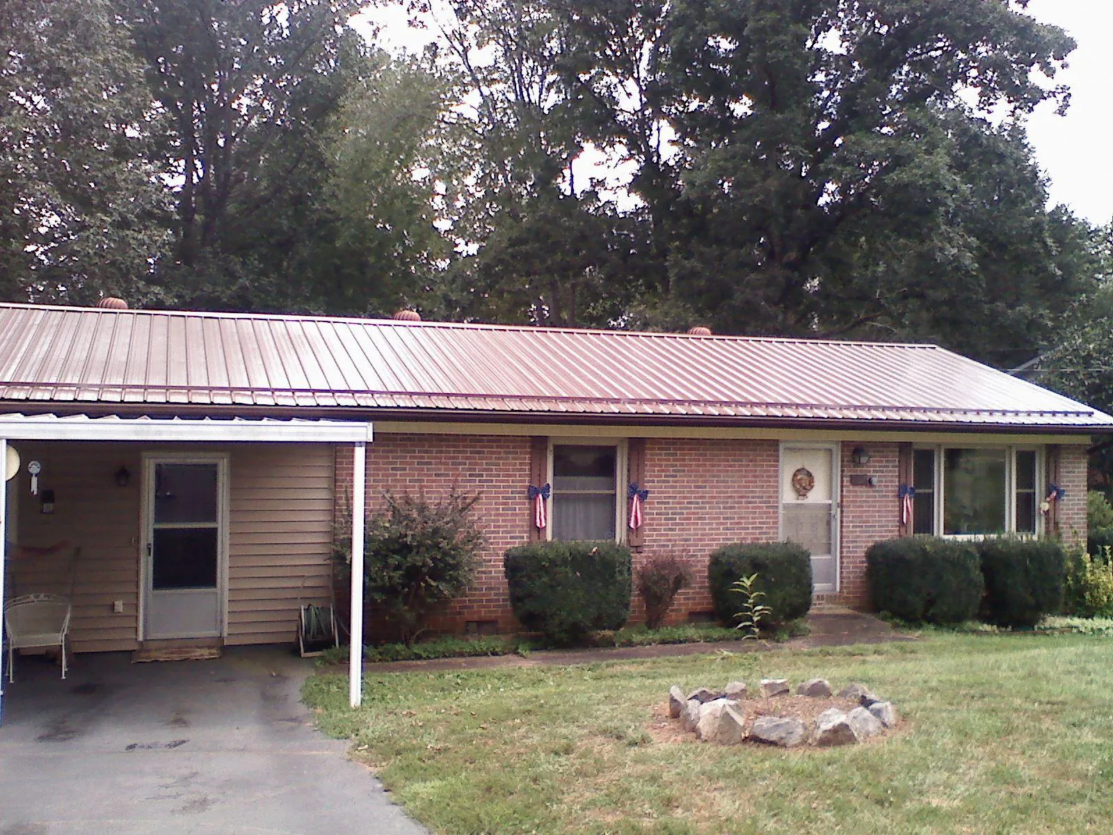 Bronze metal roof and carport on a brick ranch home — Roof Repair work by our crew in Southold